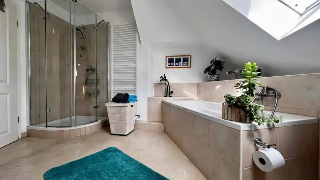 Badezimmer unter dem Dach mit Badewanne, Dusche und Dachfenster
