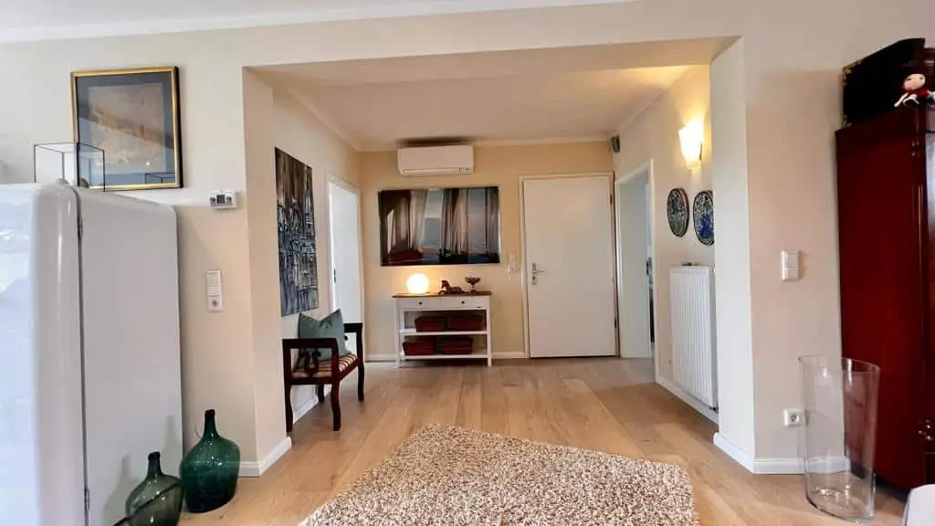 Heller Eingangsbereich mit Holzdielen, Sitzbank und Garderobe