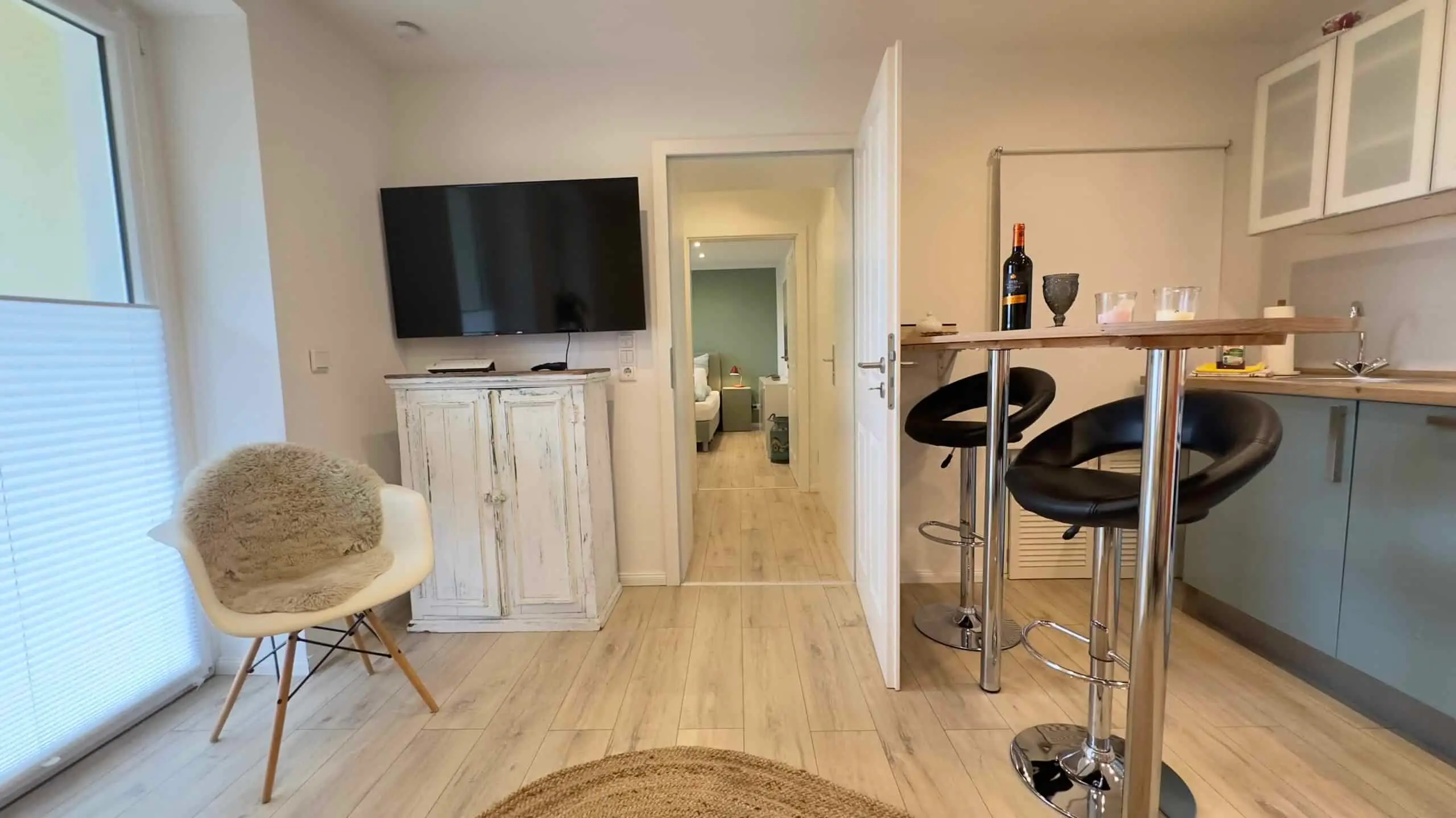 Wohnbereich mit TV, Sitzecke und Blick in den Flur der Wohnung